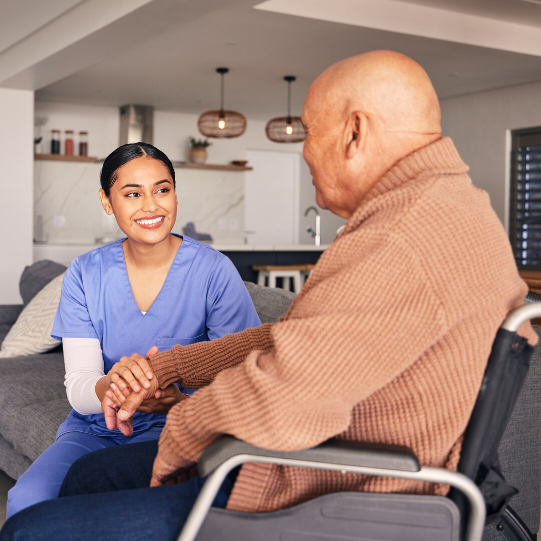 Nurse support disabled man in wheelchair with medical trust, wellness and aid in nursing home.